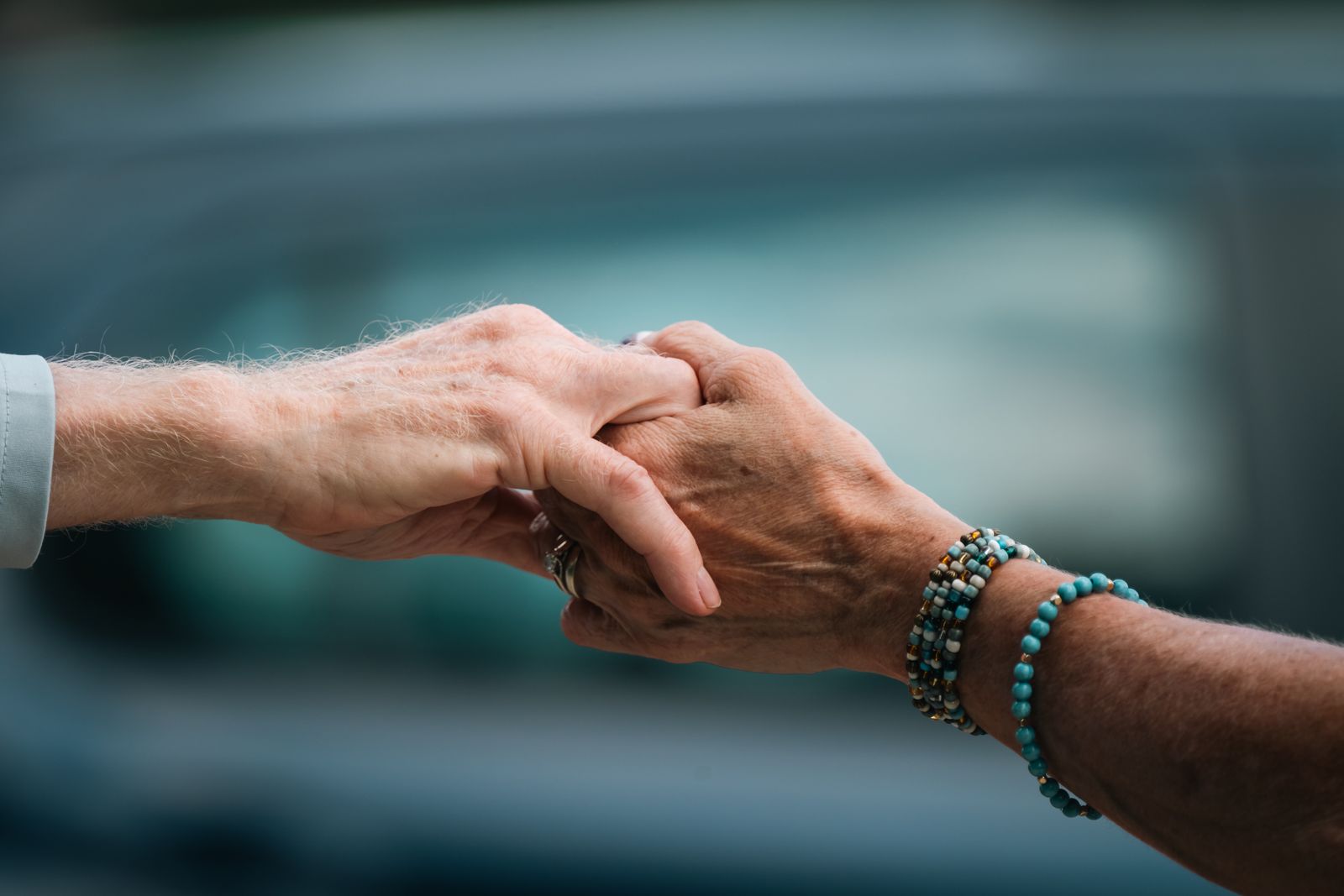 Close-up of two people holding hands in comfort and support